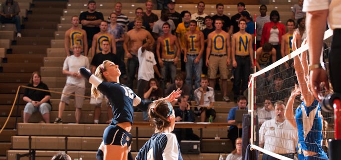 A female member of the volleyball team about to spike the ball